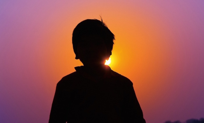 夕陽に向かっている子ども